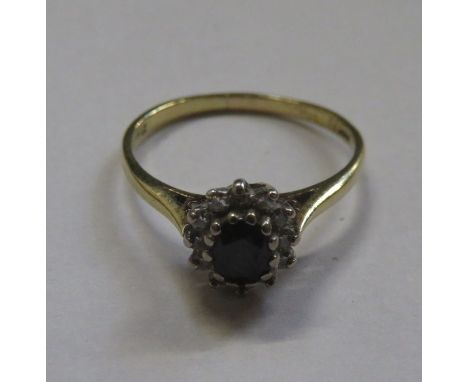 18ct GOLD DRESS RING SET WITH CENTRAL SAPPHIRE SURROUNDED BY CLEAR STONES 