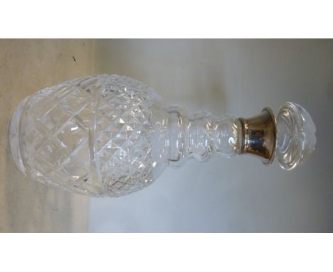A slice and diamond decorated crystal decanter of triple ringed neck design with an applied silver collar and a dome topped s