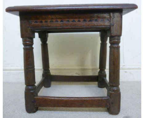 An early 18thC oak framed joint stool with a parquetry frieze, raised on ring turned, tapered, block legs, united by stretche