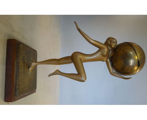 An Art Deco gilded metal and lacquered brass novelty table lighter, fashioned as a dancing nude with a sphere, on a square on