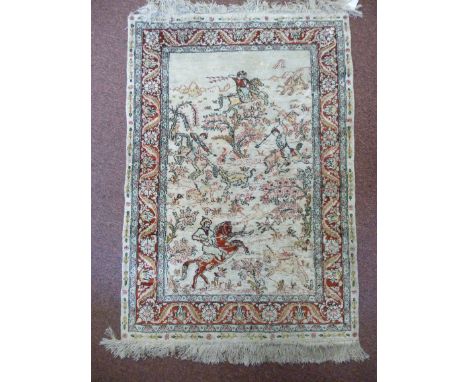 A Persian silk mat, featuring four mounted horsemen hunting wild animals, within a floral and foliate decorated border  36'' 