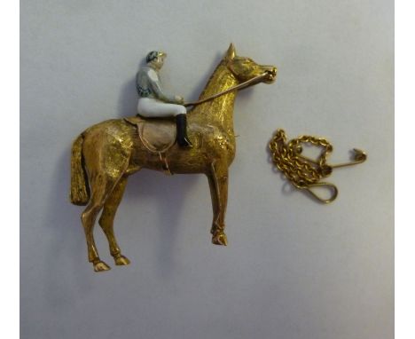 A 9ct gold and coloured enamel brooch, fashioned as a mounted jockey