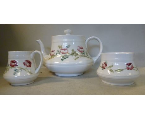 A late 19thC three piece Macintyre pottery tea set, decorated with rose garlands, on a cream coloured ground, comprising a te