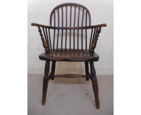 A mid 19thC beech, ash and elm framed Windsor chair, having a hoop and stick back, curved level arms and a solid moulded seat