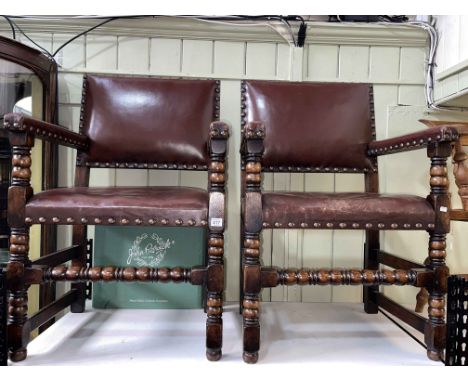 Pair studded hide elbow chairs on bobbin legs.