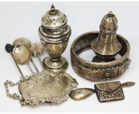 Assorted hallmarked silver comprising a stamp case, two pepperettes, a port decanter label, four bean spoons, a mustard spoon