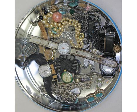 A tin containing vintage costume jewellery and watches including a silver ladies watch, silver ring and other items of silver