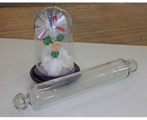 A glass rolling pin and a Victorian glass peacock under dome. 