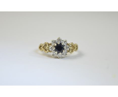 9ct Gold Set Sapphire and Diamond Cluster Ring. Flower head Setting. The Central Sapphire Surrounded by 9 Small Diamonds. Ful