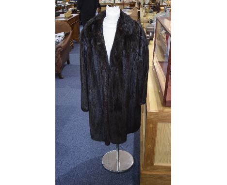 Dark Brown Mink Mid-Length Coat. Collared coat with hook and eye fastenings, two side slit pockets lined in brown velvet. Unu