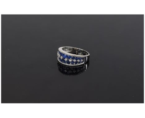 Sapphire and White Zircon Band Ring, two rows of graduated, round cut, blue sapphires, to either side of a row of natural whi