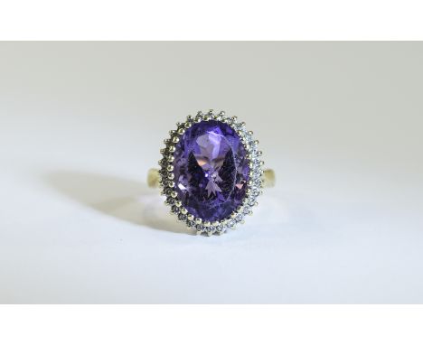 9ct Gold Diamond Dress Ring Set with a large central Amethyst Coloured stone surrounded by small round cut diamonds. Hallmark