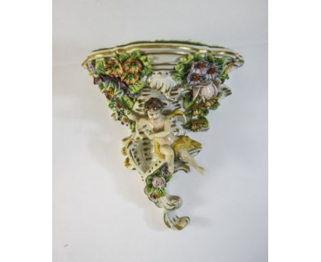 Sitzendorf Porcelain Wall Bracket decorated in bold relief with cherubs, flowers and foliage, 6 x 5 Inches