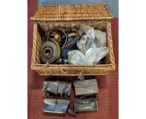 Four leather vintage tool bags, various leather belts and buckles, contained in a wicker basket 