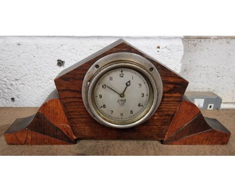 A Smith dashboard mounted clock, mounted in a display case.The clock winds and is ticking.