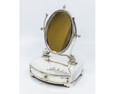 An Edwardian silver mounted dressing table mirror, oval mirror with central finial, fitted velvet lined drawer on stepped fee