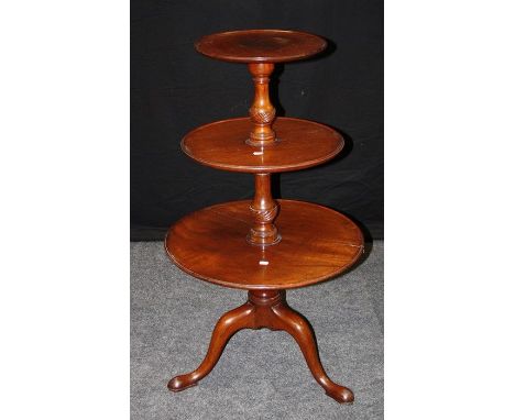 A George III mahogany dumb waiter, with three dish-top tiers surrounding a tapering and sprial turned column, raised on tripo