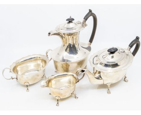 A George V silver four-piece tea set comprising teapot, hot water pot, milk and sugar, flared wavy rims above plains bodies o