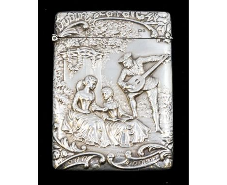 An Edwardian silver card case, the front chased with a group of 18th Century figures: two ladies seated and a gentleman's pla