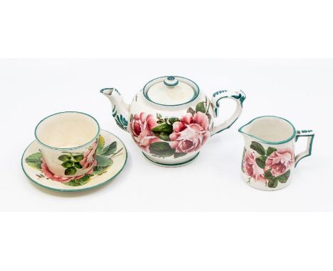 An early century Wemyss teapot, milk jug, sugar bowl and saucer, all decorated with pink cabbage roses, all stamped to bases 