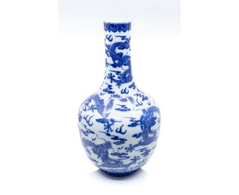 A Chinese blue and white 'nine' dragon bottle vase, Jiaqing mark and period (1796-11820), the rounded sides rising from a sho