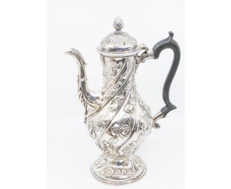 A George III silver baluster shaped coffee pot, the body wyvern fluted, chased and embossed with trailing flowers and foliage