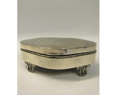 Early 20c silver jewel casket of serpentine form with engine turned sunburst to hinged cover, the base supported on four roco