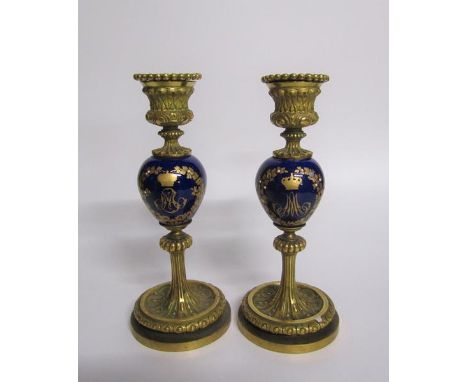 A pair of late 19c ormolu and ceramic candlesticks, the ceramic knops with jewelled gilt wreath designs crowned and each bear