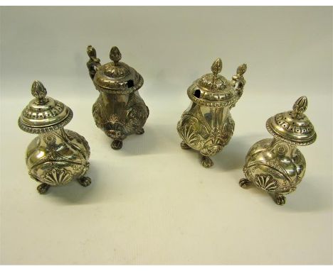 A Victorian four piece silver condiment, each item of embossed baluster form and supported on three paw feet.  Comprising two