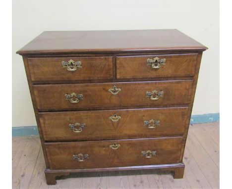 Late Georgian figured walnut veneered chest of two short and three long drawers, all with brass fittings under a top with mou