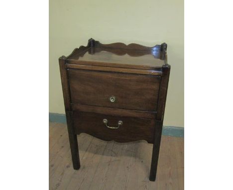 A George III mahogany tray top bedroom commode with a cupboard enclosed by a hinged lift up door over a pull out base, on squ