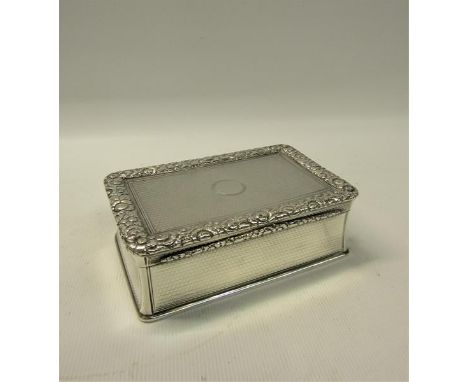 An early Victorian silver table snuff box of rectangular form, the hinge cover with a cast border of leaf and flowers, surrou