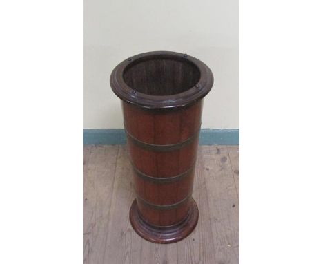 A late 19c mahogany stick stand of cylindrical form, brass banded and supported on a circular moulded base.  30cms w x 66cms 