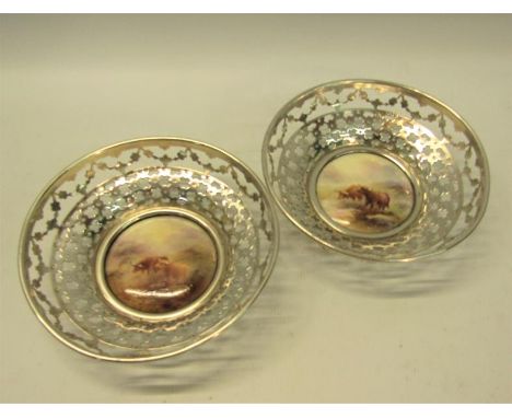 A pair of circular silver bowls, pierced and with James Stinton Royal Worcester bases, both decorated with highland cattle in