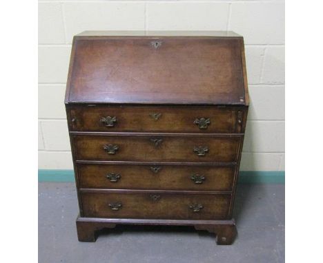 A late Georgian mahogany bureau with fall front and fitted interior over three long drawers and one dummy drawer, with bracke