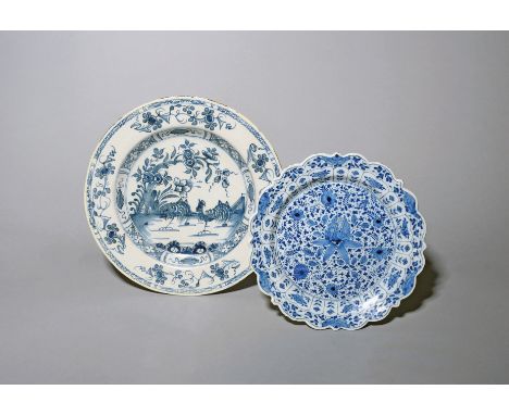 A Liverpool delftware plate  c.1740-50, the well painted in blue with two strutting cockerels beneath flowering branches, and