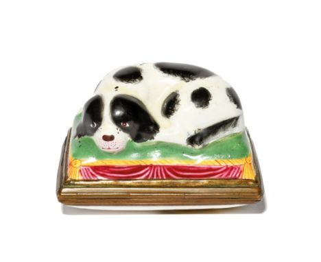 A Bilston enamel bonbonnière c.1760-80, modelled as a Cavalier spaniel recumbent on a rectangular green tasselled cushion, it