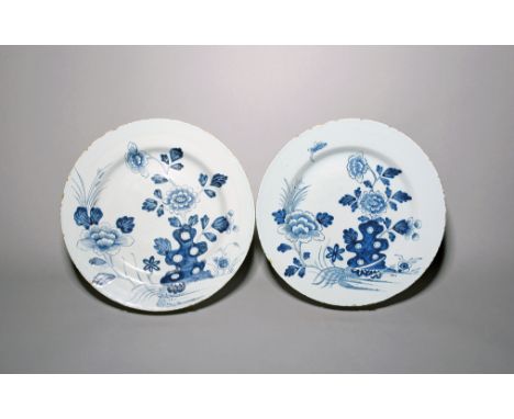 A pair of delftware chargers  c.1760, probably Liverpool, painted in blue with bold branches of flowering peony issuing from 