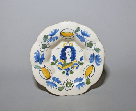 A small Delft lobed dish  c.1690, painted in blue, green and yellow with a portrait of King William, flanked by the initials 