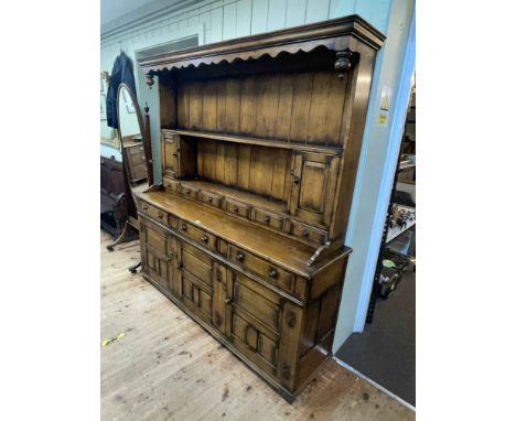 Oak dresser having shelf, cupboard and spice drawer back above a base of three frieze drawers with panelled doors below, 191c