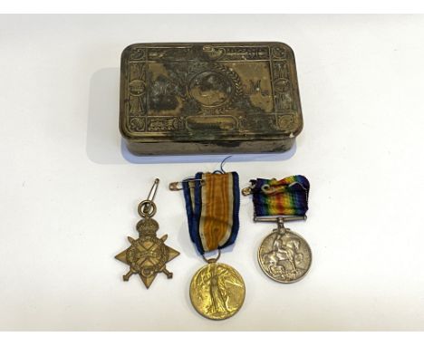 A First World War Christmas tin, containing three First World War medals