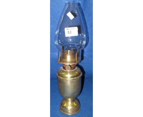 All brass single burner oil lamp of baluster form with clear chimney.