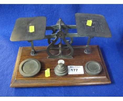 Set of brass postal scales with weights on oak base.