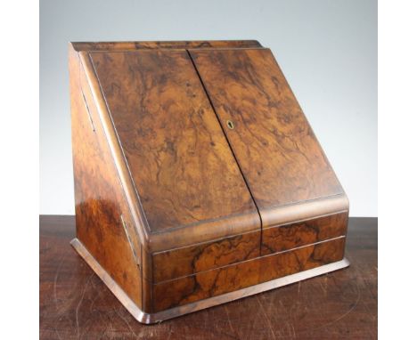 A Victorian walnut stationery cabinet, the sloping pair of doors opening to reveal a lift-out calendar, letter space, glass i