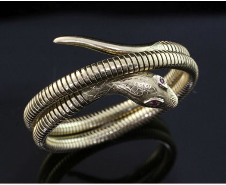 An early 1960's Victorian style 9ct gold coiled serpent bracelet, with engraved decoration and ruby set eyes, Smith & Pepper 