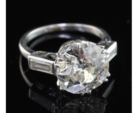 A mid 20th century platinum and single stone diamond ring, with baguette cut diamond set shoulders, the central round brillia