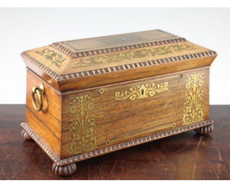 A Regency rosewood and brass inlaid sarcophagus shaped tea caddy, with quarter reel mouldings, the hinged lid opening to reve