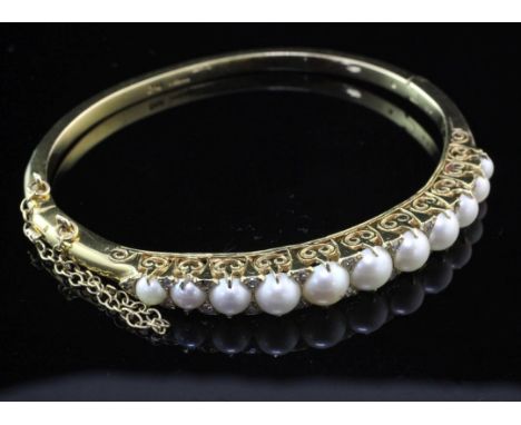 A Victorian style 9ct gold, graduated split cultured pearl and diamond set hinged bangle, with safety chain, gross weight 20.