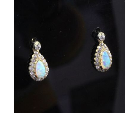 A pair of early 20th century gold, white opal and diamond drop earrings, each set with pear shaped opal bordered with round c