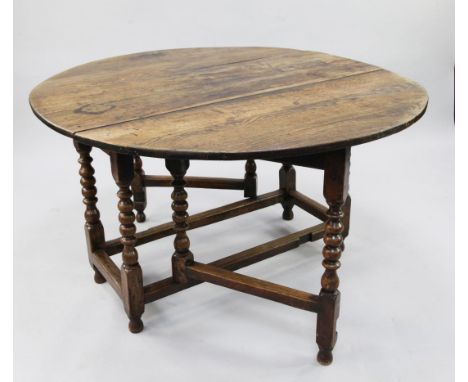An early 18th century oak oval gate leg table, with bobbin turned supports united by stretchers, extended 4ft